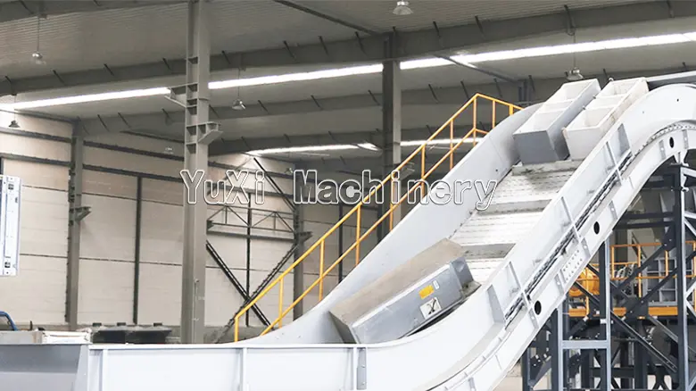 Inclined conveyor belt moving parts on the refrigerator recycling line.