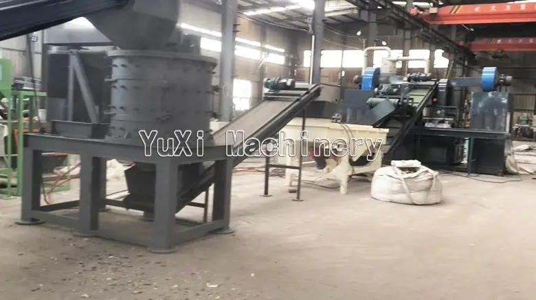 Vertical metal crusher and conveyor belt setup for motor rotor recycling.