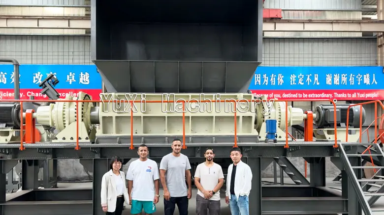 YuXi Machinery staff and clients standing in front of the large car shredder.