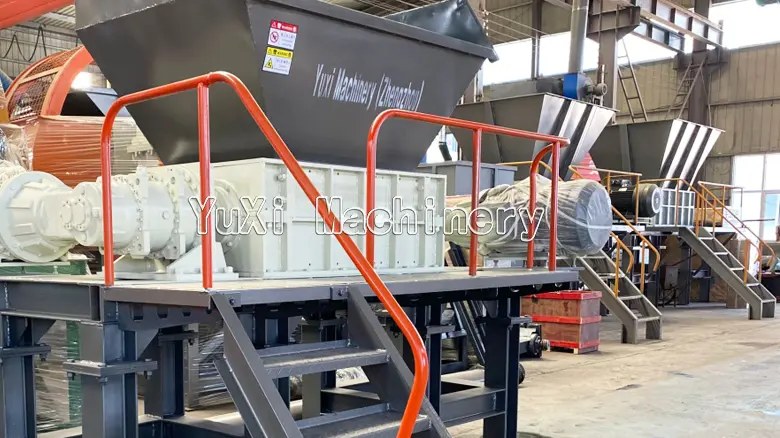 Two double-shaft metal shredders installed in a factory, showing the large feed hopper and motor units.