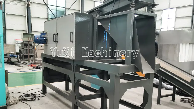 Side view of the eddy current separator, showing the discharge chute and vibrating feeder component.