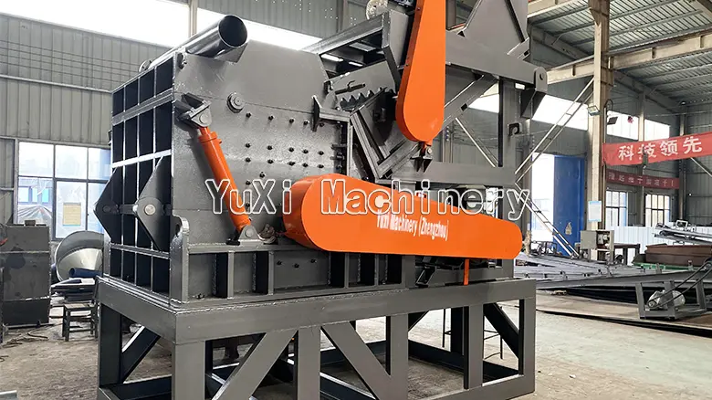 Heavy-duty hammer mill metal crusher installed in a workshop, showing the robust housing and material input area.